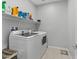 Functional laundry room featuring modern washer and dryer units, shelving, and ample storage space at 143 Aqua Commons Ln, Henderson, NV 89015