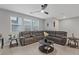 Inviting living room featuring a plush, oversized sectional, neutral tones, and a modern ceiling fan at 143 Aqua Commons Ln, Henderson, NV 89015