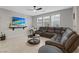 Cozy living room with a large sectional sofa, modern decor, and natural light, perfect for relaxing at 143 Aqua Commons Ln, Henderson, NV 89015