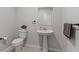 Cozy powder room with a modern pedestal sink, sleek fixtures, neutral tones, and stylish decor at 143 Aqua Commons Ln, Henderson, NV 89015