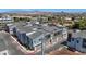 View of modern townhouses featuring gray siding, private garages, and street parking at 143 Aqua Commons Ln, Henderson, NV 89015