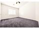 Empty bedroom with neutral walls, gray carpet, ceiling fan, and a window at 1440 Summer Glow Ave, Henderson, NV 89012