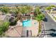 An aerial view of the community pool, with palm trees, lounge chairs, and a separate hot tub at 1440 Summer Glow Ave, Henderson, NV 89012