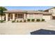Inviting single-story home with a tile roof and attached two-car garage, surrounded by green bushes at 1440 Summer Glow Ave, Henderson, NV 89012