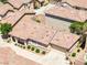 An eye-level, aerial view of a one-story home with a tile roof, beige walls, and a two-car garage at 1440 Summer Glow Ave, Henderson, NV 89012