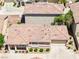 An eye-level, aerial view of a one-story home with a tile roof, beige walls, and a two-car garage at 1440 Summer Glow Ave, Henderson, NV 89012