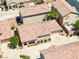 An eye-level, aerial view of a one-story home with a tile roof, beige walls, and a two-car garage at 1440 Summer Glow Ave, Henderson, NV 89012