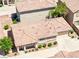 An eye-level, aerial view of a one-story home with a tile roof, beige walls, and a two-car garage at 1440 Summer Glow Ave, Henderson, NV 89012