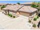 A side view shows the beige home, a two-car garage, desert landscaping, and tile roof at 1440 Summer Glow Ave, Henderson, NV 89012