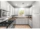 Modern kitchen with white cabinets, stainless steel oven and microwave, and tile flooring at 1440 Summer Glow Ave, Henderson, NV 89012