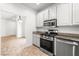 Contemporary kitchen features white cabinets, stainless steel appliances, and an open layout at 1440 Summer Glow Ave, Henderson, NV 89012