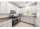 Bright kitchen featuring white cabinetry, stainless steel appliances, and a window above the sink at 1440 Summer Glow Ave, Henderson, NV 89012