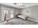 Comfortable bedroom featuring a ceiling fan, plush carpet, and sliding door access to the backyard at 1940 Canterbury Dr, Las Vegas, NV 89119