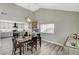 Open dining area featuring modern lighting fixture, white walls, gray wood floors, and kitchen view at 1940 Canterbury Dr, Las Vegas, NV 89119