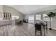 Open dining room with gray wood floors, large windows, stylish light fixture, and access to the patio at 1940 Canterbury Dr, Las Vegas, NV 89119
