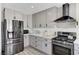 Modern kitchen with stainless steel appliances, gray cabinets, and black range hood at 1940 Canterbury Dr, Las Vegas, NV 89119