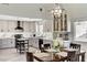 Modern kitchen featuring gray cabinets, stainless steel appliances, quartz countertops, and a dining table at 1940 Canterbury Dr, Las Vegas, NV 89119