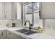 Kitchen with black double bowl sink, gooseneck faucet, white countertops, and gray cabinets at 1940 Canterbury Dr, Las Vegas, NV 89119