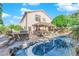 Backyard oasis with a custom pool, outdoor kitchen, and tropical landscaping for relaxation at 204 Appian Way, Henderson, NV 89002
