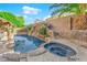 Amazing backyard with a rock waterfall, built-in spa, and lush tropical landscaping at 204 Appian Way, Henderson, NV 89002