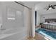 The stylish bathroom features a soaking tub with shower, white tiling, and shuttered window at 204 Appian Way, Henderson, NV 89002