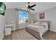Comfortable bedroom featuring neutral colors, a ceiling fan, and a sunny window at 204 Appian Way, Henderson, NV 89002
