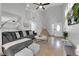 Open-concept living room featuring a cozy sofa, staircase and bright natural light at 204 Appian Way, Henderson, NV 89002