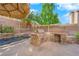 Built-in outdoor kitchen features a grill, stone facade, and tile countertops next to the pool at 204 Appian Way, Henderson, NV 89002