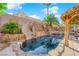 Resort style pool featuring a slide, waterfall, lush landscaping and tiki-style covered patio at 204 Appian Way, Henderson, NV 89002