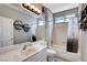 Clean bathroom featuring a tub, shower, and stylish fixtures; well-lit with a large mirror and storage at 2078 Wildwood Lake St, Henderson, NV 89052