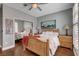 Bright bedroom with hardwood floors, a window with shutters, a wooden bed frame, and mirrored closet doors at 2078 Wildwood Lake St, Henderson, NV 89052
