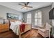 Serene bedroom with a large window with shutters, hardwood floors, a wooden bed frame, and modern lighting at 2078 Wildwood Lake St, Henderson, NV 89052