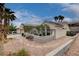 Attractive home with a well-maintained front yard, desert landscaping, and mature palm trees at 2078 Wildwood Lake St, Henderson, NV 89052