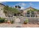 Charming front exterior featuring a decorative gate, lush landscaping, and well-maintained desert landscaping at 2078 Wildwood Lake St, Henderson, NV 89052