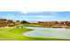 Scenic golf course view with a tranquil pond and lush green grass against a backdrop of mountain views at 2078 Wildwood Lake St, Henderson, NV 89052