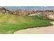 Beautiful green golf course with a sand trap and cityscape in the background at 2078 Wildwood Lake St, Henderson, NV 89052