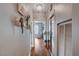 Hallway decorated with plants and decorative items leading to a bright seating area, with mirrored closet doors at 2078 Wildwood Lake St, Henderson, NV 89052
