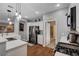 Open concept kitchen featuring stainless appliances, white cabinets, stone countertops, and hardwood flooring at 2078 Wildwood Lake St, Henderson, NV 89052