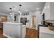 Open concept kitchen featuring stainless appliances, white cabinets, stone countertops, and hardwood flooring at 2078 Wildwood Lake St, Henderson, NV 89052