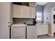 Bright laundry room with washer, dryer, sink and custom white cabinets at 2078 Wildwood Lake St, Henderson, NV 89052