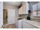 Bright laundry room with a washing machine, dryer, sink, and ample cabinet space at 2078 Wildwood Lake St, Henderson, NV 89052