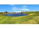 Scenic view of the golf course with a pond surrounded by lush green grass under a blue sky at 2078 Wildwood Lake St, Henderson, NV 89052