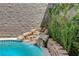 Unique rock waterfall feature with lush greenery adds natural beauty to this sparkling in-ground pool at 2078 Wildwood Lake St, Henderson, NV 89052