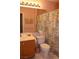 Cozy bathroom with a floral shower curtain, wood vanity, and soft pink walls at 2148 Hidden Ranch Ter, Henderson, NV 89052