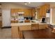 Well-lit kitchen with wood cabinetry, tile floors, breakfast bar, and modern appliances at 2148 Hidden Ranch Ter, Henderson, NV 89052