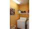 Functional laundry room with a white washing machine, storage shelf, and bright paint at 2148 Hidden Ranch Ter, Henderson, NV 89052