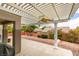 Backyard patio area with overhead pergola, fan, concrete floors, and desert landscaping at 2164 Eagle Sticks Dr, Henderson, NV 89012