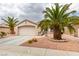 Charming single-story home featuring desert landscaping, complemented by mature palm trees and a two-car garage at 2164 Eagle Sticks Dr, Henderson, NV 89012