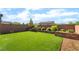 A backyard featuring a spacious lawn and nicely designed retaining wall at 23 Strada Barbera, Henderson, NV 89011