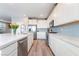 Open kitchen boasts white cabinets, stainless appliances, island, and modern finishes at 23 Strada Barbera, Henderson, NV 89011